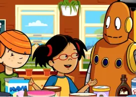 Annie, Moby, and a friend stand in a kitchen with ingredients on the table.