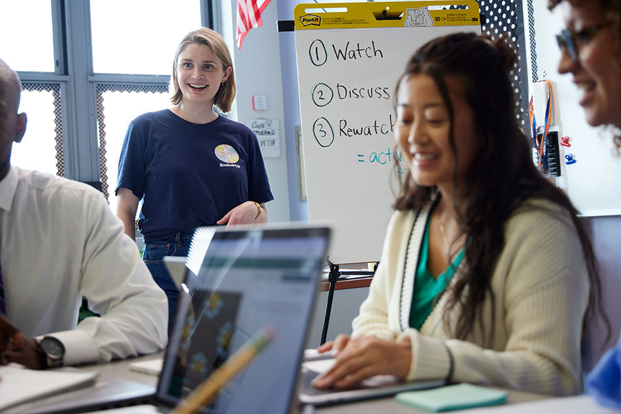 Group of teachers listening to professional instruction. Watch, Discuss, Re-watch written on board and computers are open to BrainPOP interface.