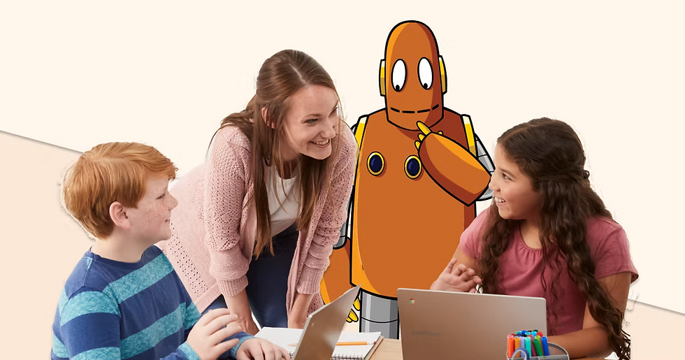 A teacher talks with two students at desks, working on computers. Moby, the orange robot, smiles behind them.