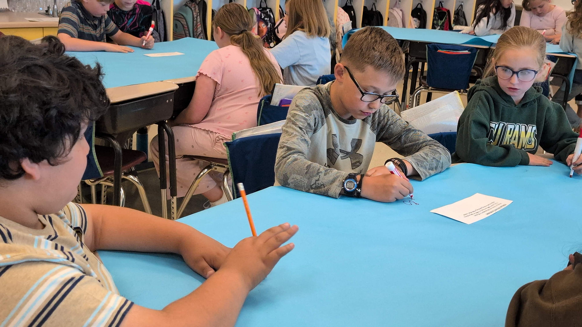 Students working out math problems on blue paper