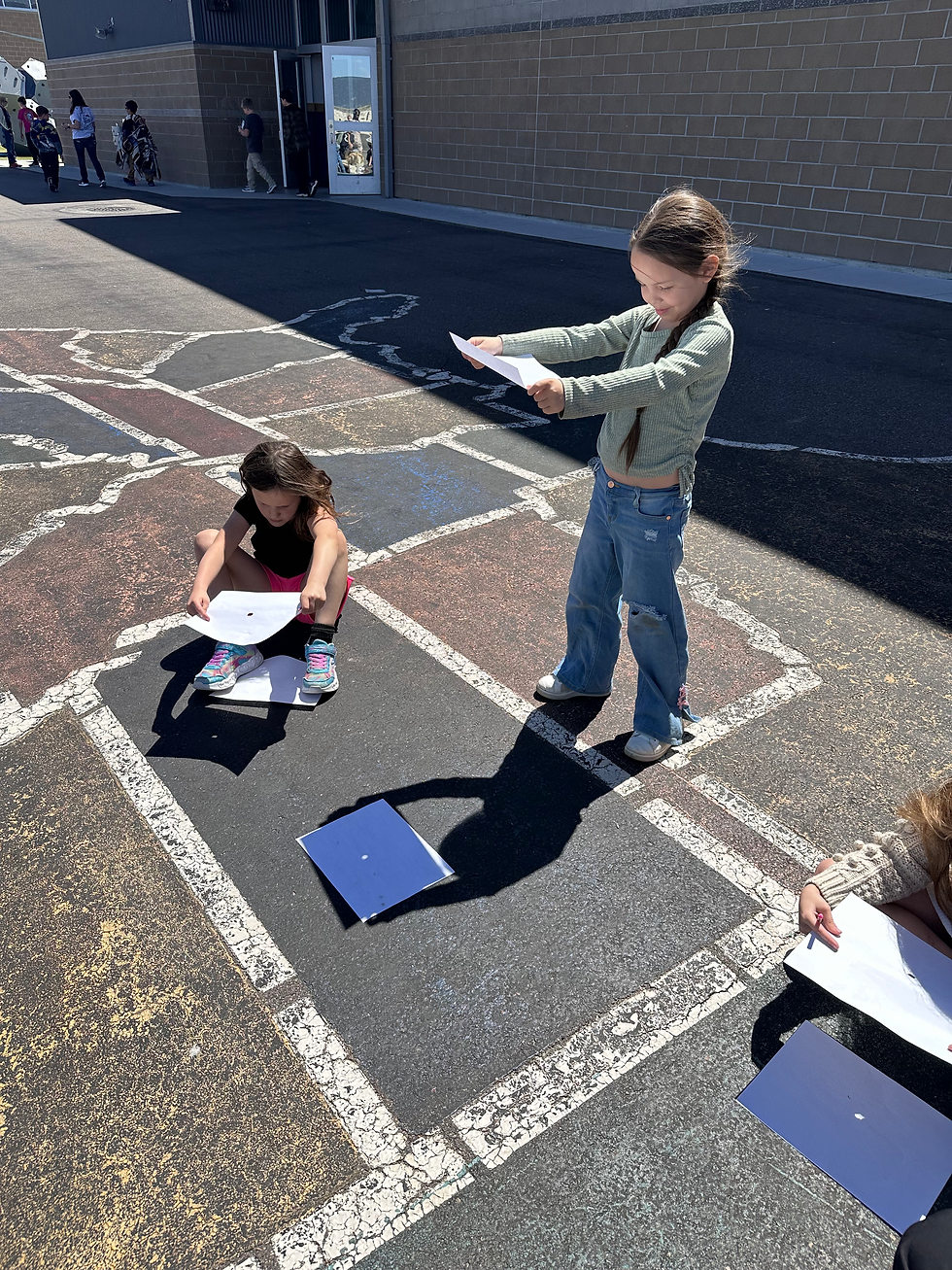 Students participating in a hands-on learning activity outside about the sun.