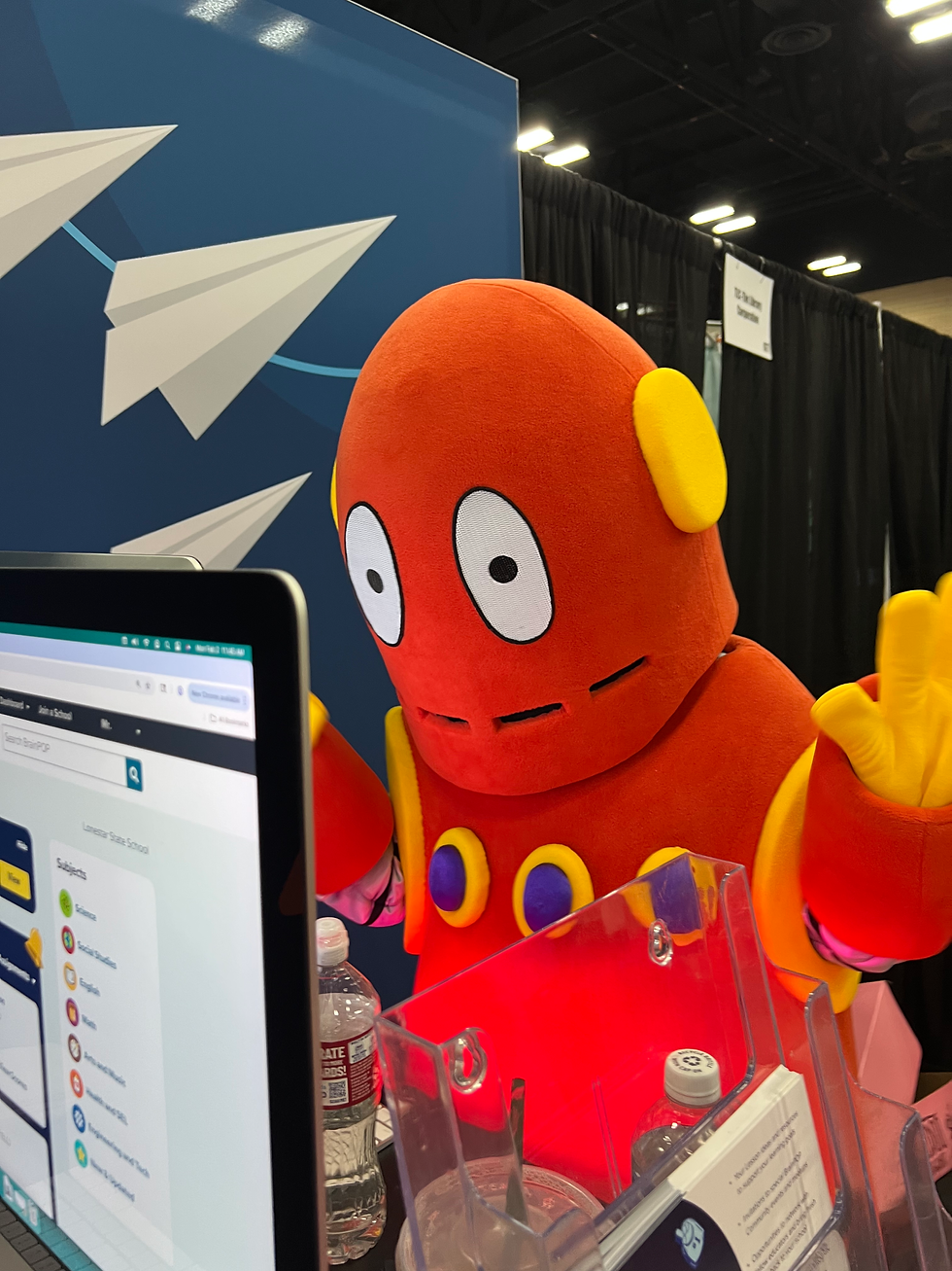 Lifesize Moby mascot posing next to a screen showing BrainPOP's platform interface