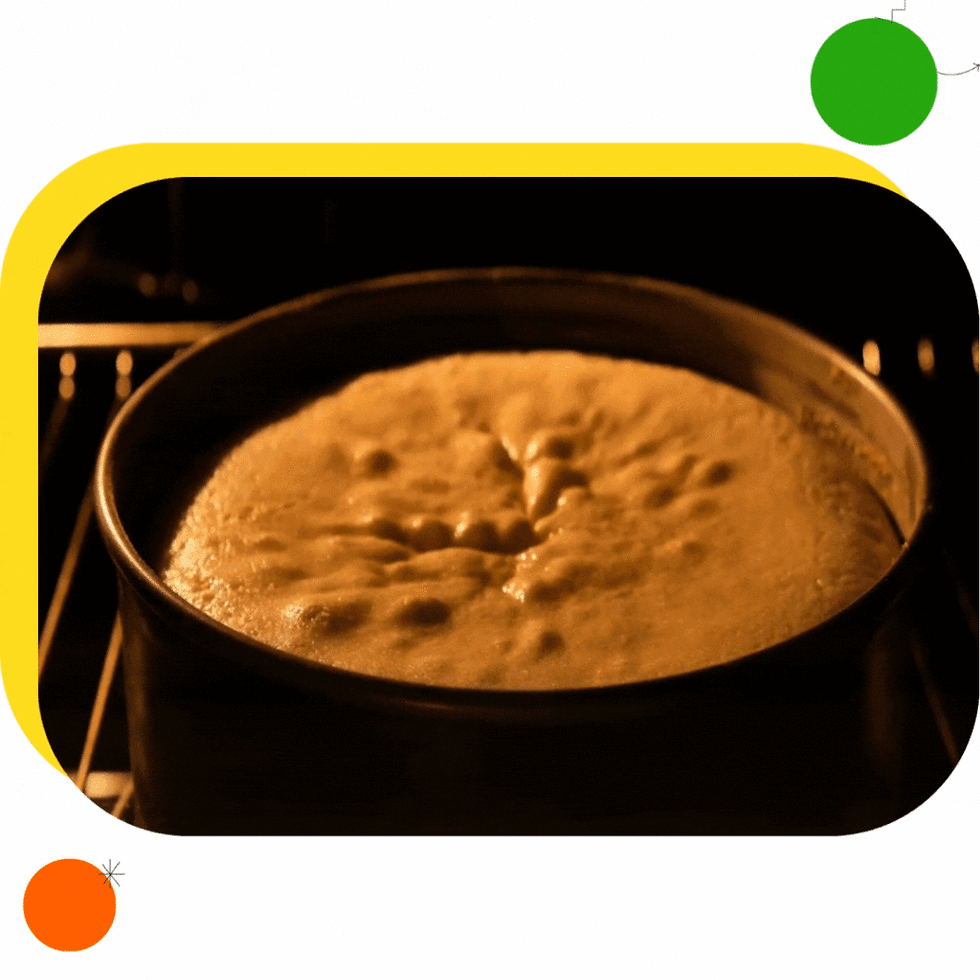 Cake baking in an oven, golden and rising in a round pan. Warm lighting creates a cozy atmosphere. Graphic yellow frame with circles.
