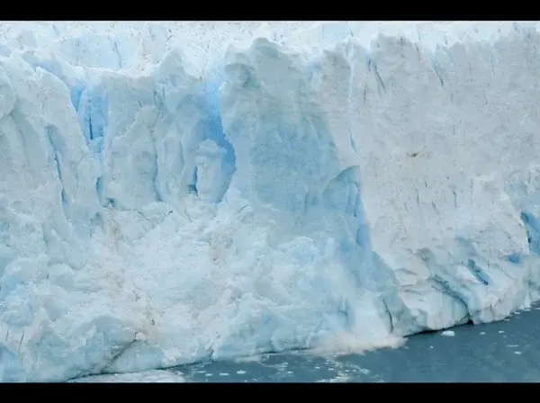 Glacier with ice breaking away and crashing into the water